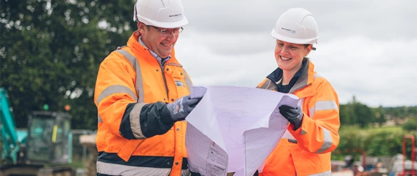 Employees on site in PPE Looking At Site Plans